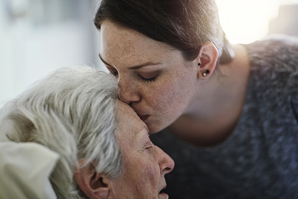 A woman kissing her senior mother. 