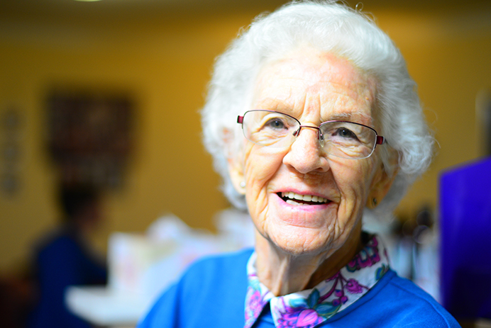 A smiling elderly woman in a retirement home